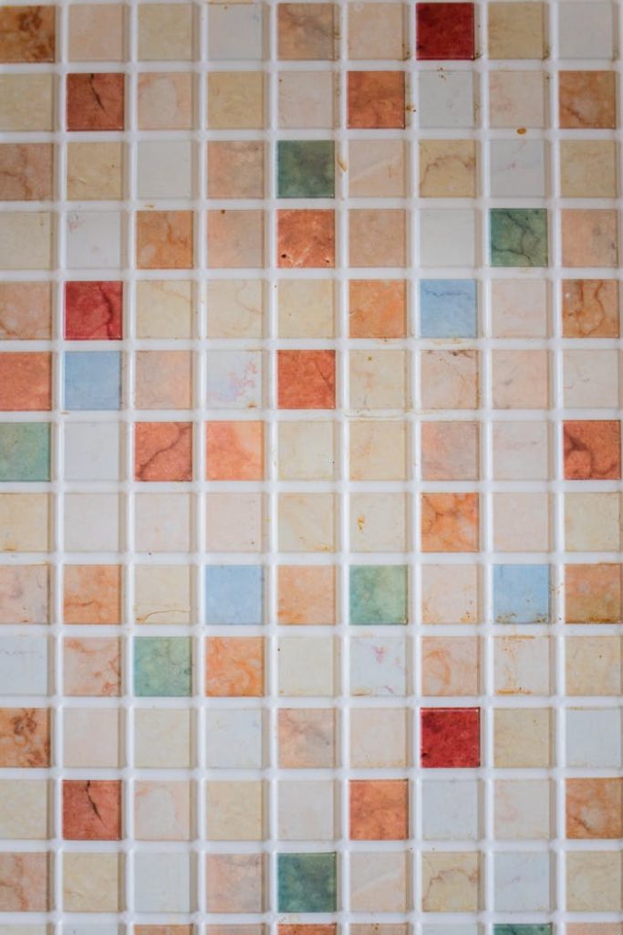abstract-backdrop-of-multicolored-tiled-floor-7794425 A vibrant mosaic tile wall with multicolored geometric patterns.